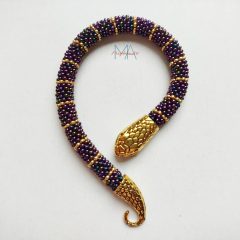   Irizáló lila-arany gyöngyhorgolt karkötő kígyófejes kapoccsal